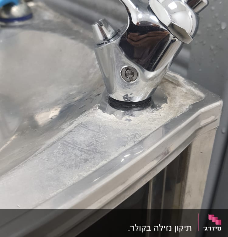 ברז מתכת עם סימני חלודה על הכיור